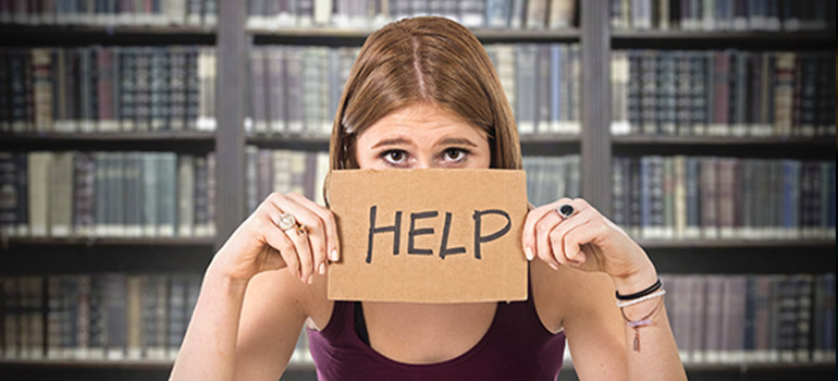 Medical student holding up help sign