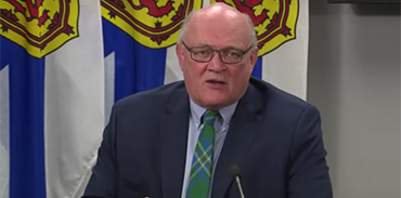 Dr. Robert Strang with Nova Scotia flag draped in background