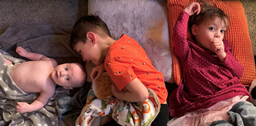 three small children laying down together