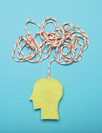 side view profile of yellow head on blue background with tangled red and white string above