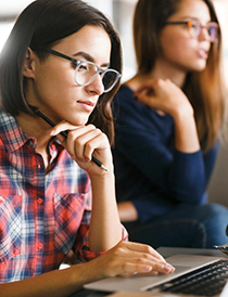 two young females studying at laptops