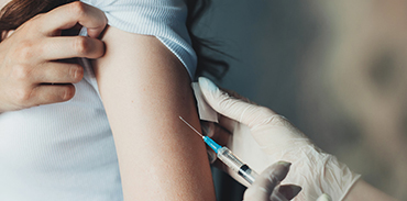 white gloved hands administering a vaccine