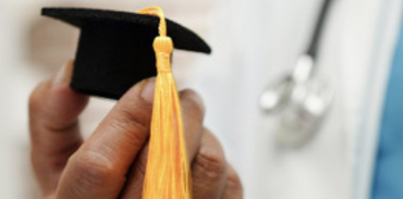 Asian woman physician holding graduation cap