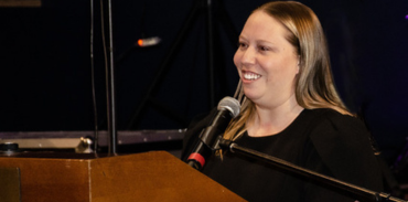 Dr. Leisha Hawker speaking at a podium