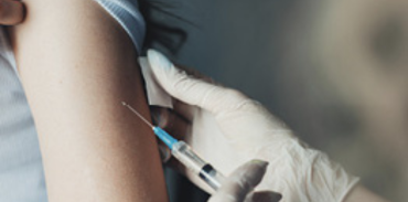 white gloved hands administering a vaccine