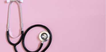 black stethoscope on pink background