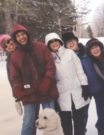 Group of five women on a winter walk with a white dog