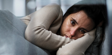 woman lying down with her head resting on both hands