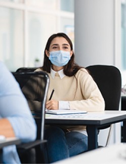 student at desk and wearing a mask