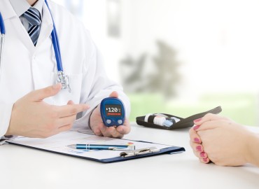 a physician sits across from a patient at a table