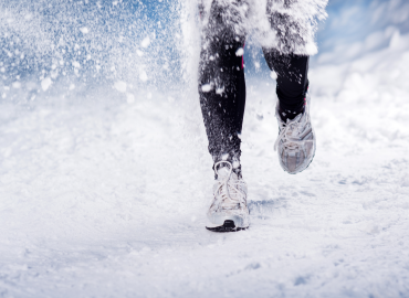 a pair of legs from knee down running in the snow